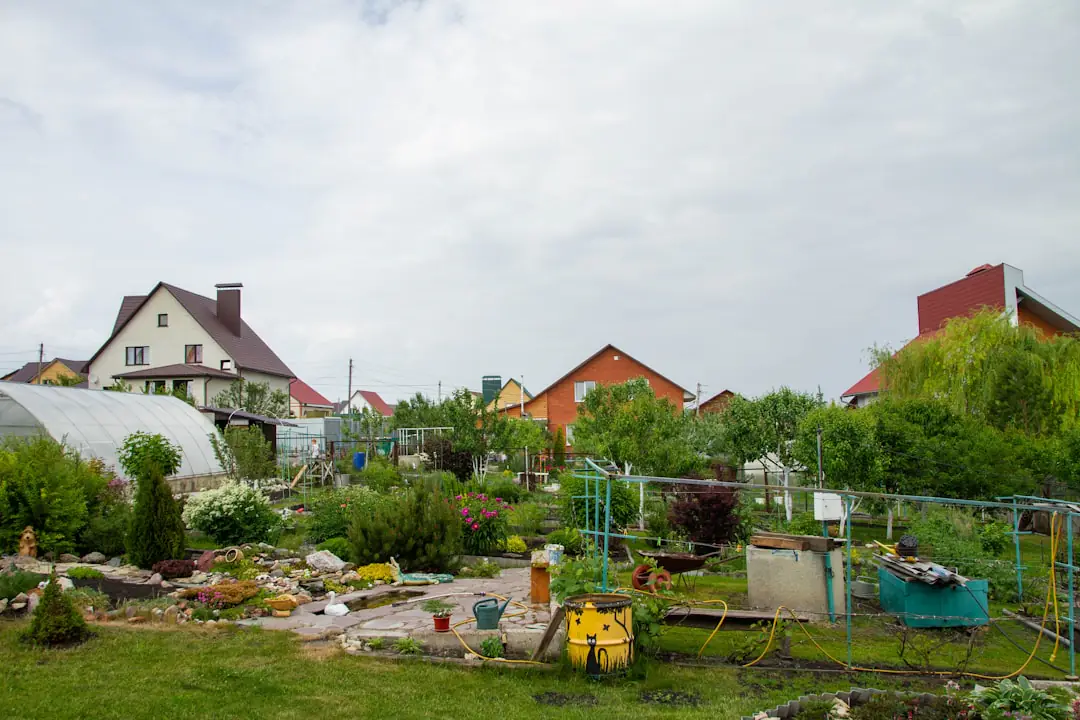 Jardin français après une tempête avec branches au sol, vivaces tuteurées et jardinière inspectant les dégâts